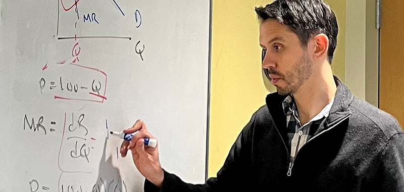 McKnight alumnus Dr. Enrique Valdes  walks students through solving equations monopolists use to set price and output.